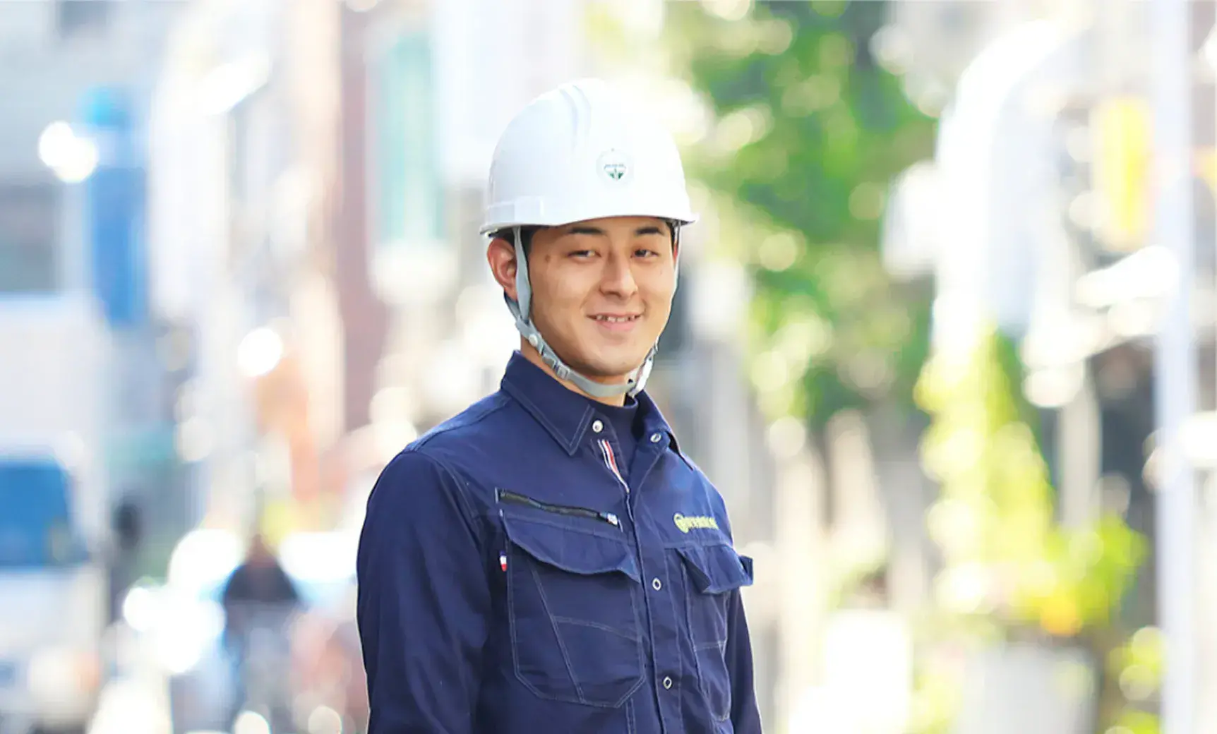 施工管理の男性社員がヘルメット着用で微笑んでいる