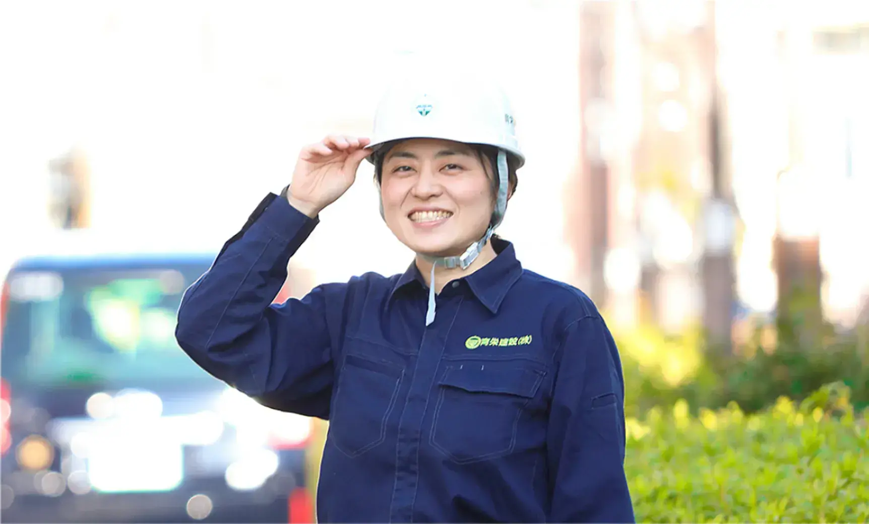 施工管理の男性社員がヘルメット着用で微笑んでいる